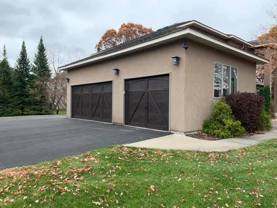 Dark carriage-style garage doors on a stucco home