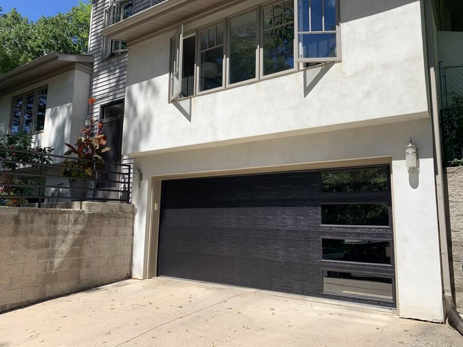 Modern black garage door with a glass panel