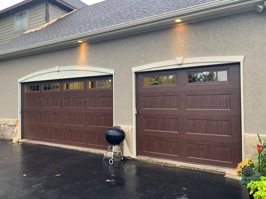 Wood-look garage doors with windows and arched trim